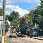 An excavator works along Austin Avenue